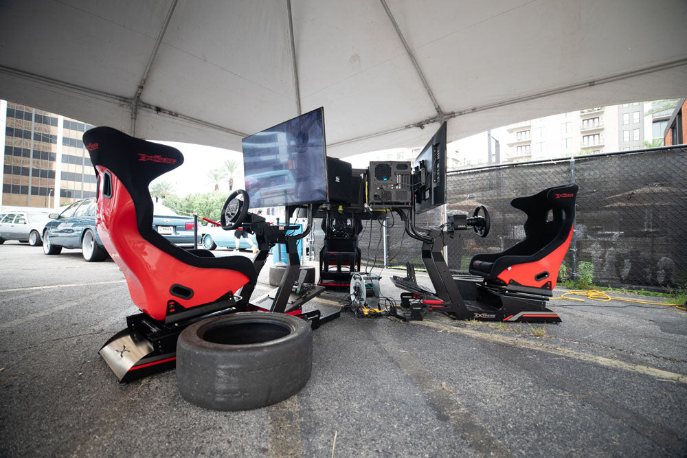 Three racing simulators set up in a star arrangement.